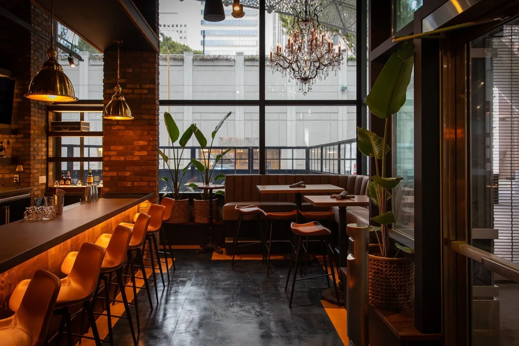 Modern bar and lounge area with brick walls and large windows.