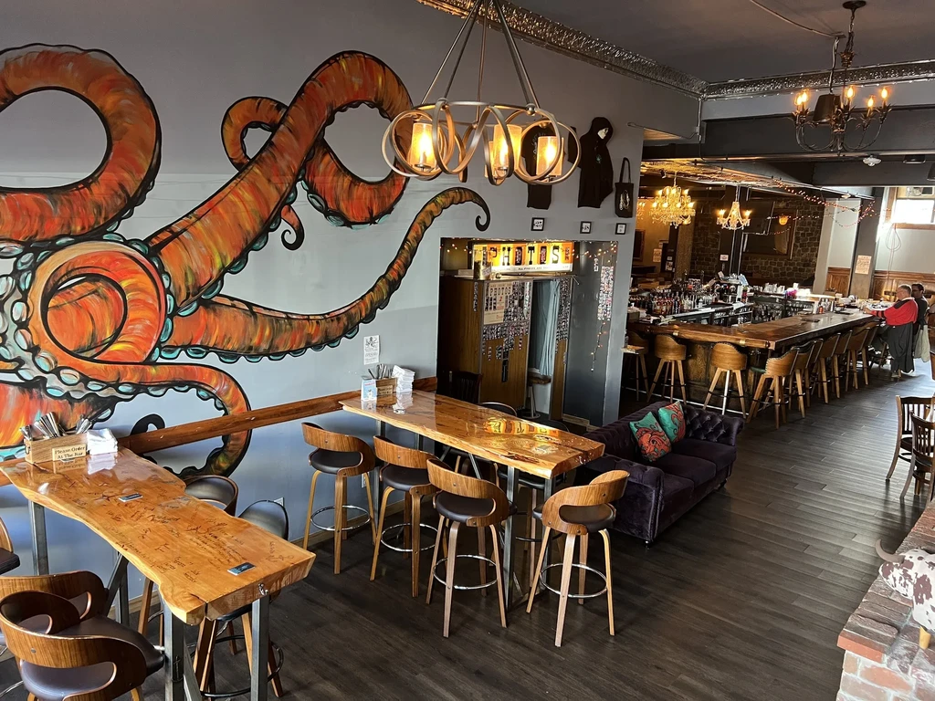 A large octopus mural on a wall in a bar and restaurant.