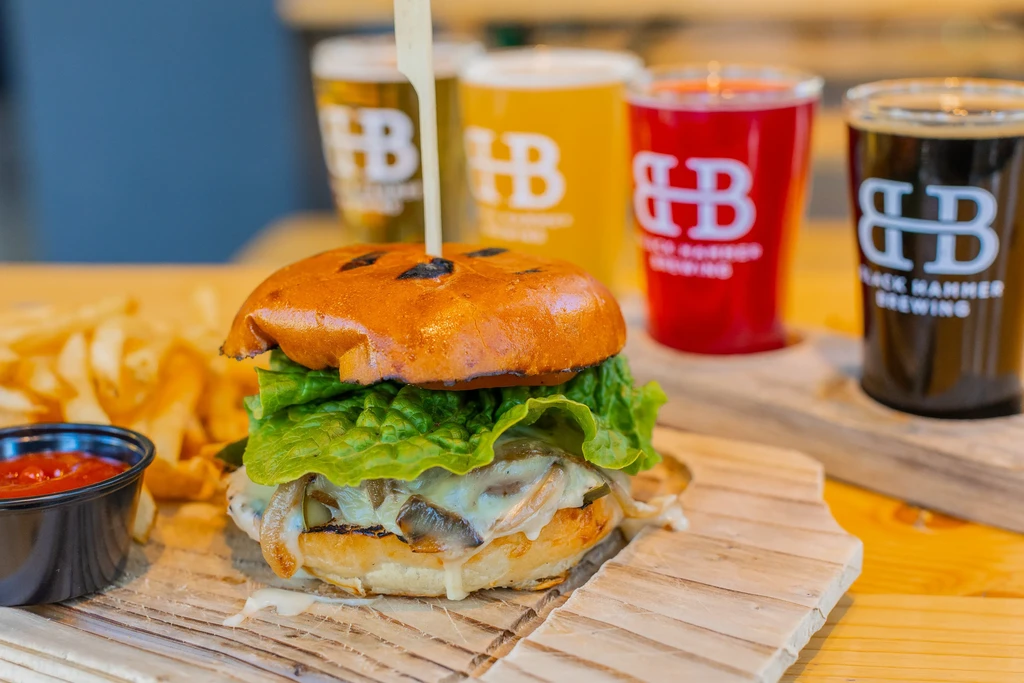 Cheeseburger with fries, ketchup, and a beer flight at Black Hammer Brewing.