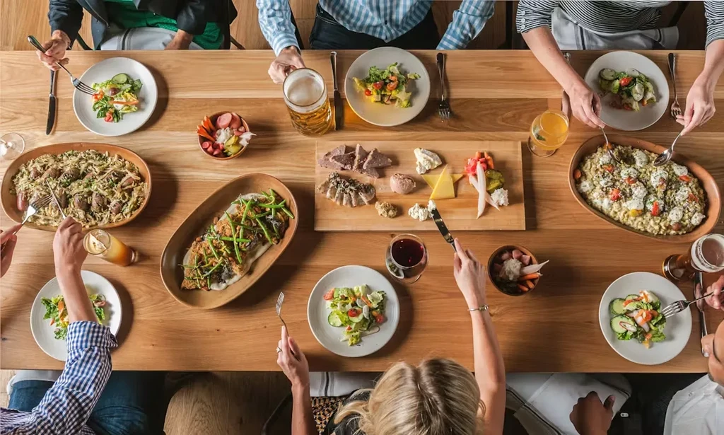 Overhead shot of people dining at a long wooden table.