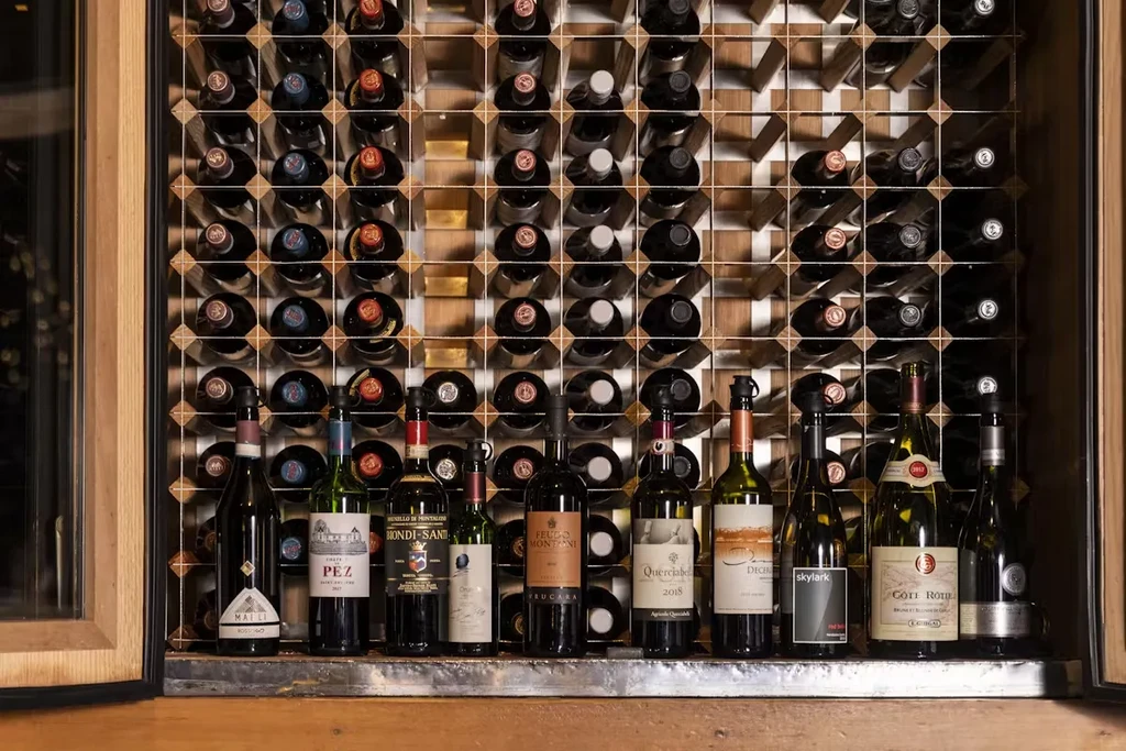 A wine rack filled with bottles, with additional bottles displayed below.