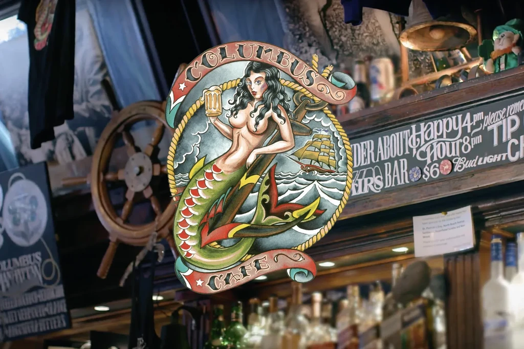 Sign for "Columbus Cafe" depicting a mermaid holding a beer mug.