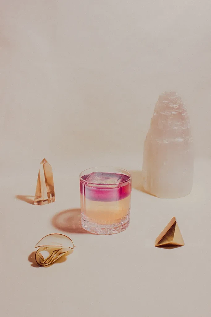 A drink, fortune cookie, two crystals, and a selenite tower.