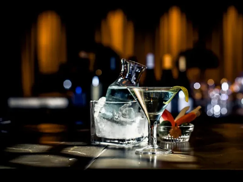 Martini glass with lemon twist and a carafe of ice water.