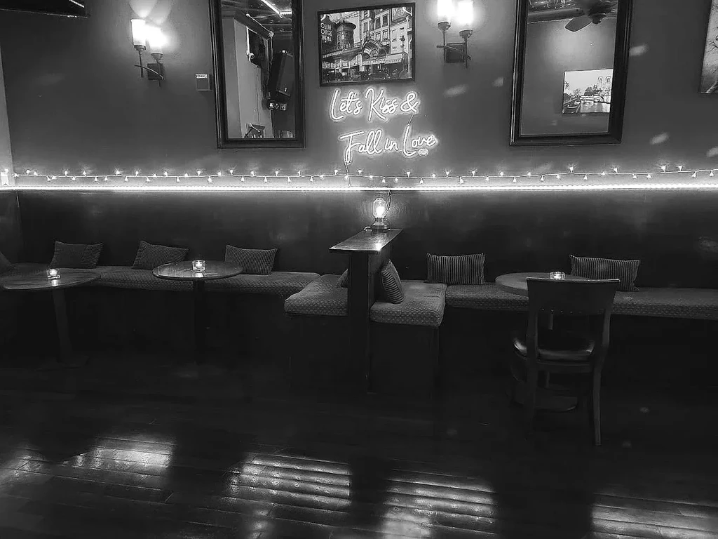Black and white image of an empty restaurant's booth seating area.