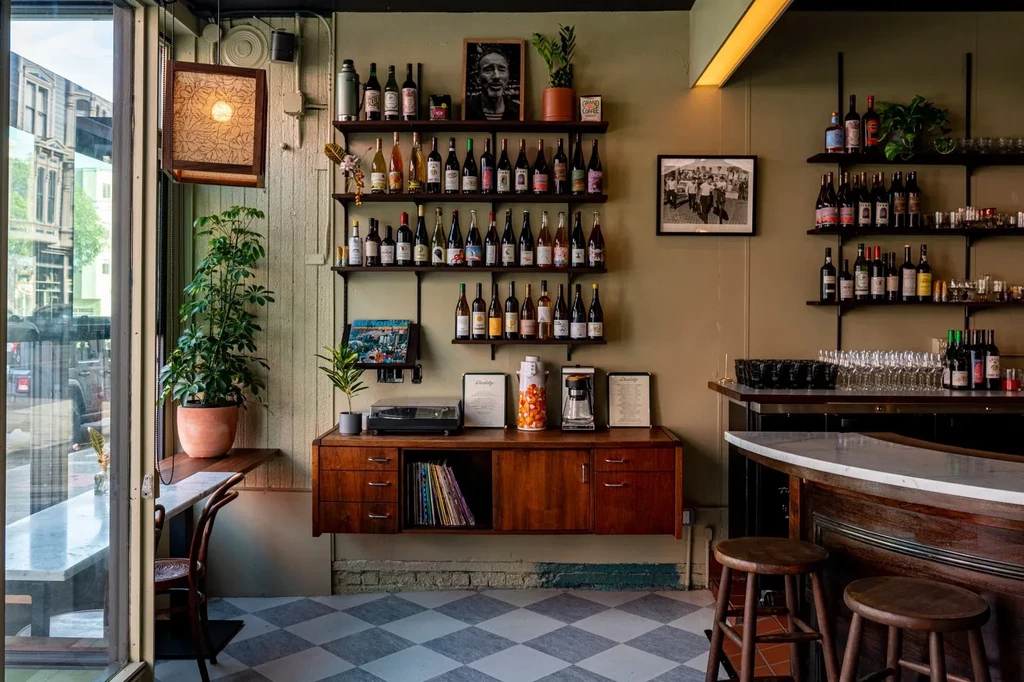 Interior of a wine bar with checkered floor and wooden furniture.