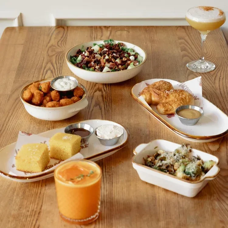 A table full of various brunch dishes, drinks, and side dishes.