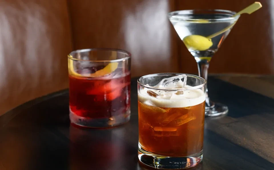 Three cocktails: a Negroni, a white Russian, and a Martini.