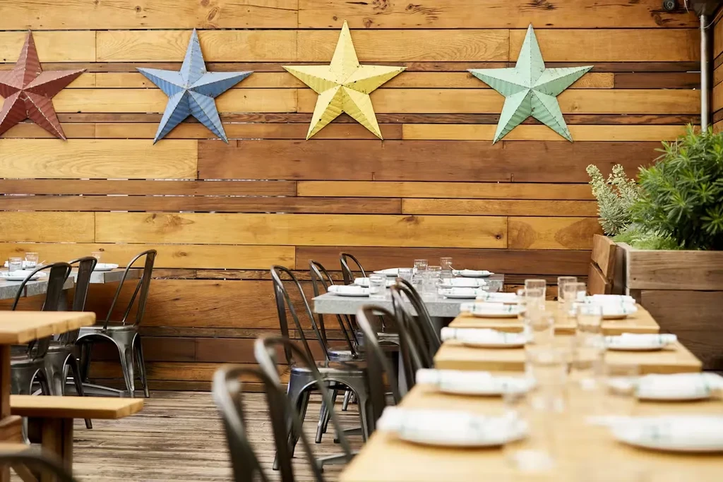 Dining area with rustic wood paneling and four large colorful stars.