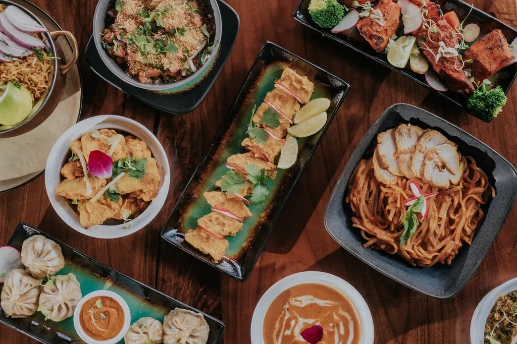 Overhead shot of various Indian dishes and entrees on a wooden table.