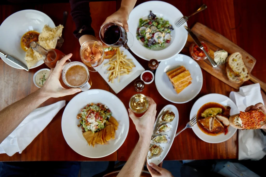 Overhead view of a dinner table with drinks, appetizers, and meals.