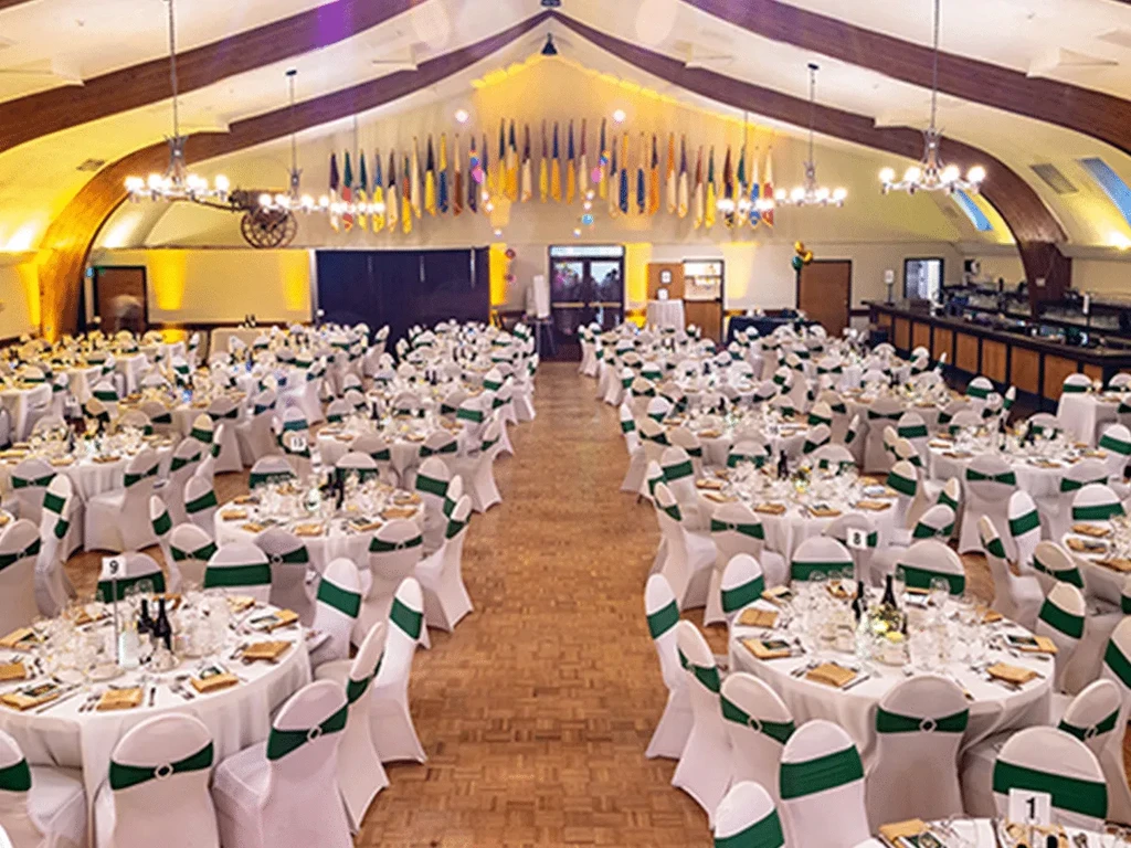 Large banquet hall set for an event with many round tables.
