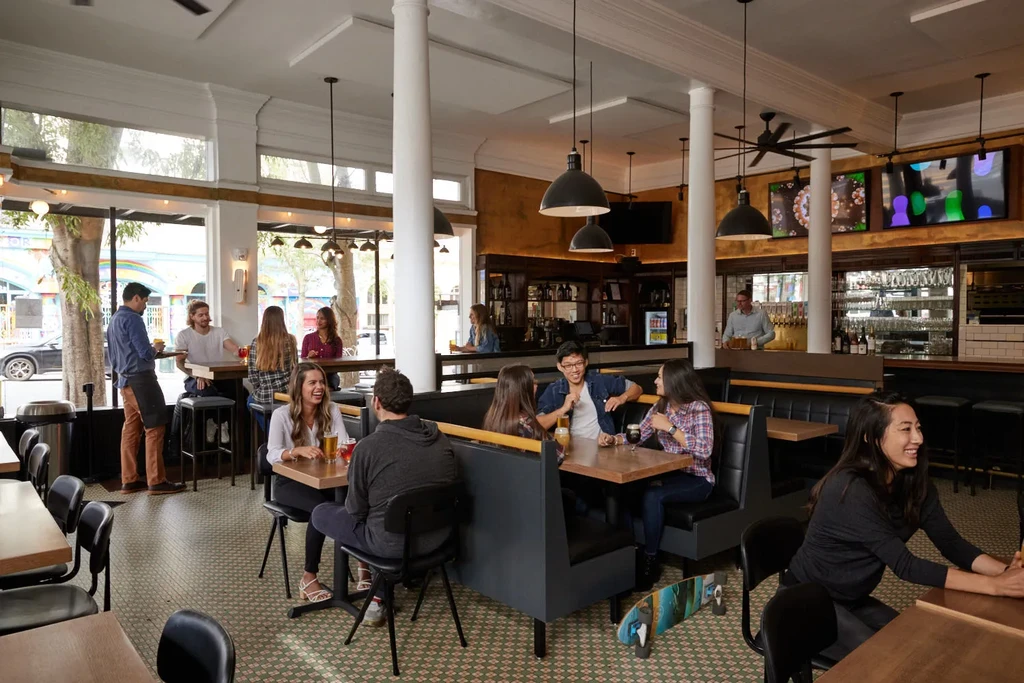 A busy, modern bar and restaurant with diverse patrons and staff.