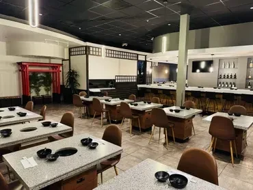 An empty, modern Japanese hot pot restaurant with an Asian-inspired bar.