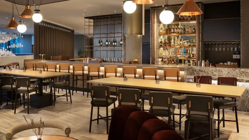 A modern bar and lounge with various seating options and full liquor display.