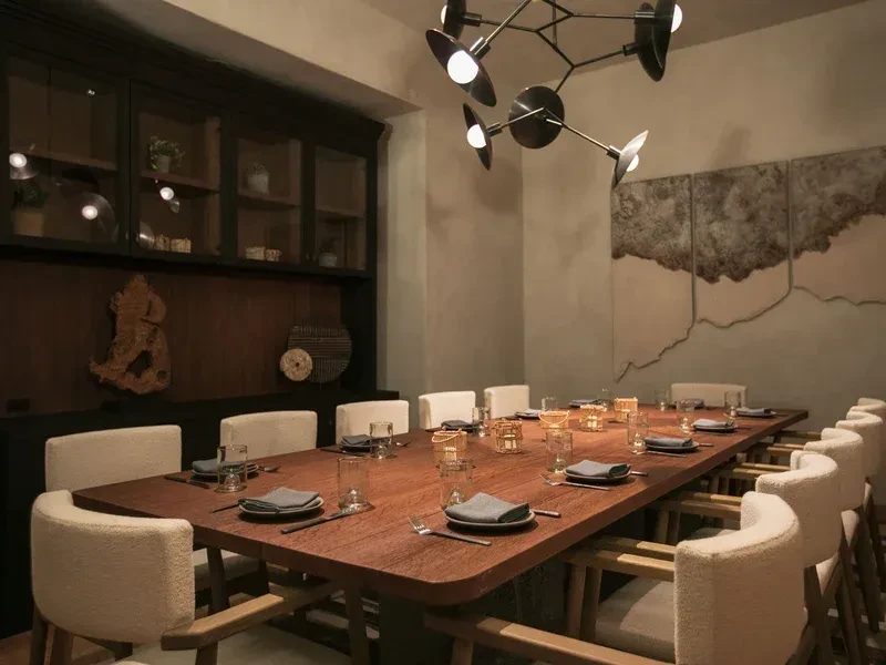 A long dining table in a modern restaurant with decorative artwork.