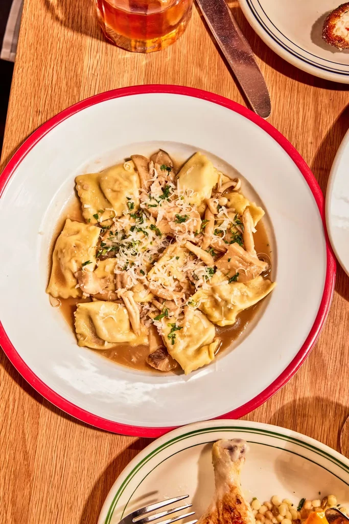 Ravioli with mushrooms and cheese, a drink, and a chicken leg.