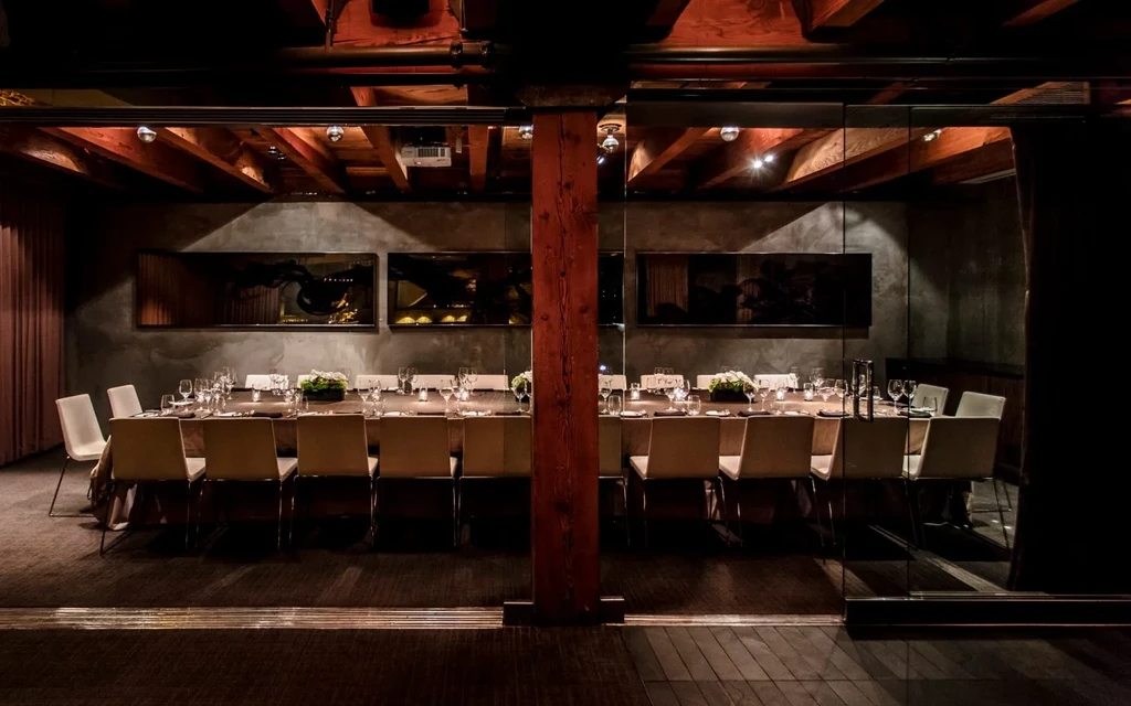 A long banquet table set with chairs and place settings.