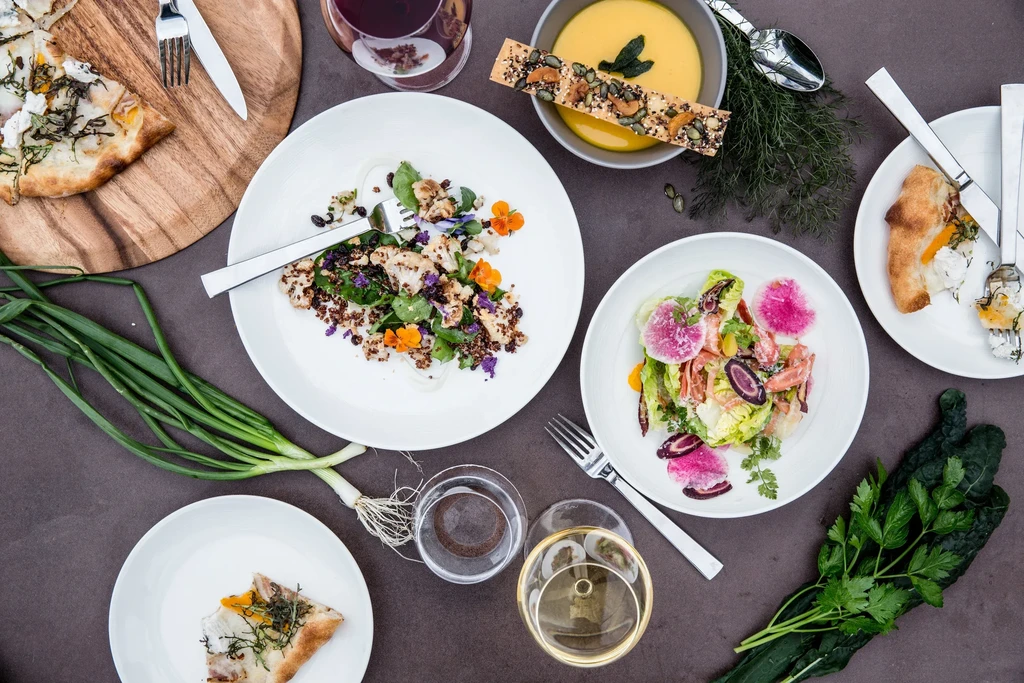 A top-down view of various gourmet dishes, drinks, and fresh produce.