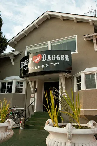 Building exterior with 'Heart and Dagger Saloon' sign above entrance.