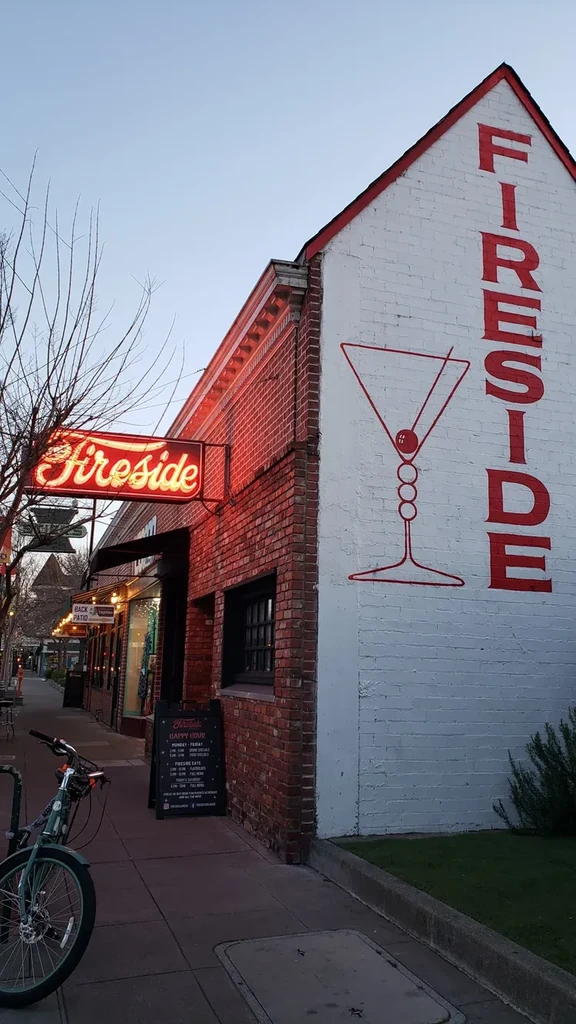 A bar called "Fireside" with a neon sign and martini glass mural.