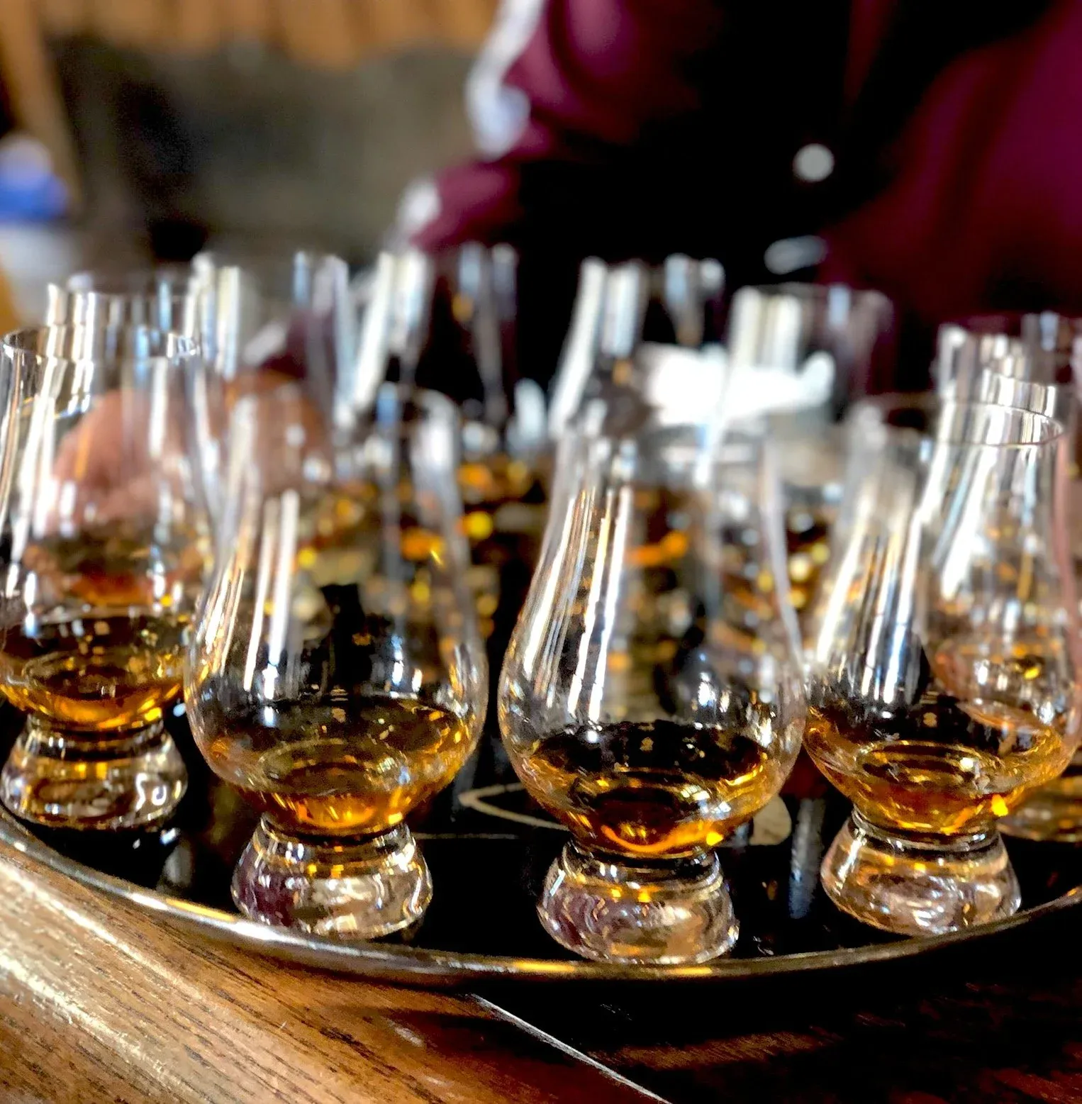 A tray of glencairn glasses filled with amber liquid for tasting.