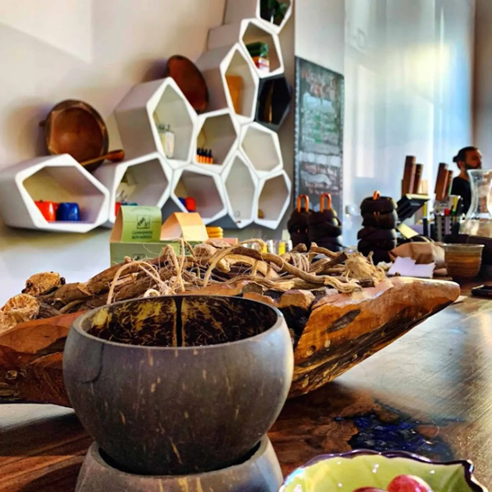 Interior of a cafe with hexagonal wall shelves and natural decor.
