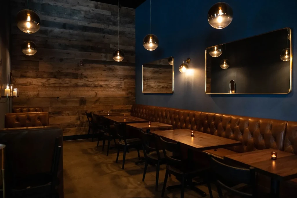 A cozy restaurant with wood-paneled walls and a long leather booth.