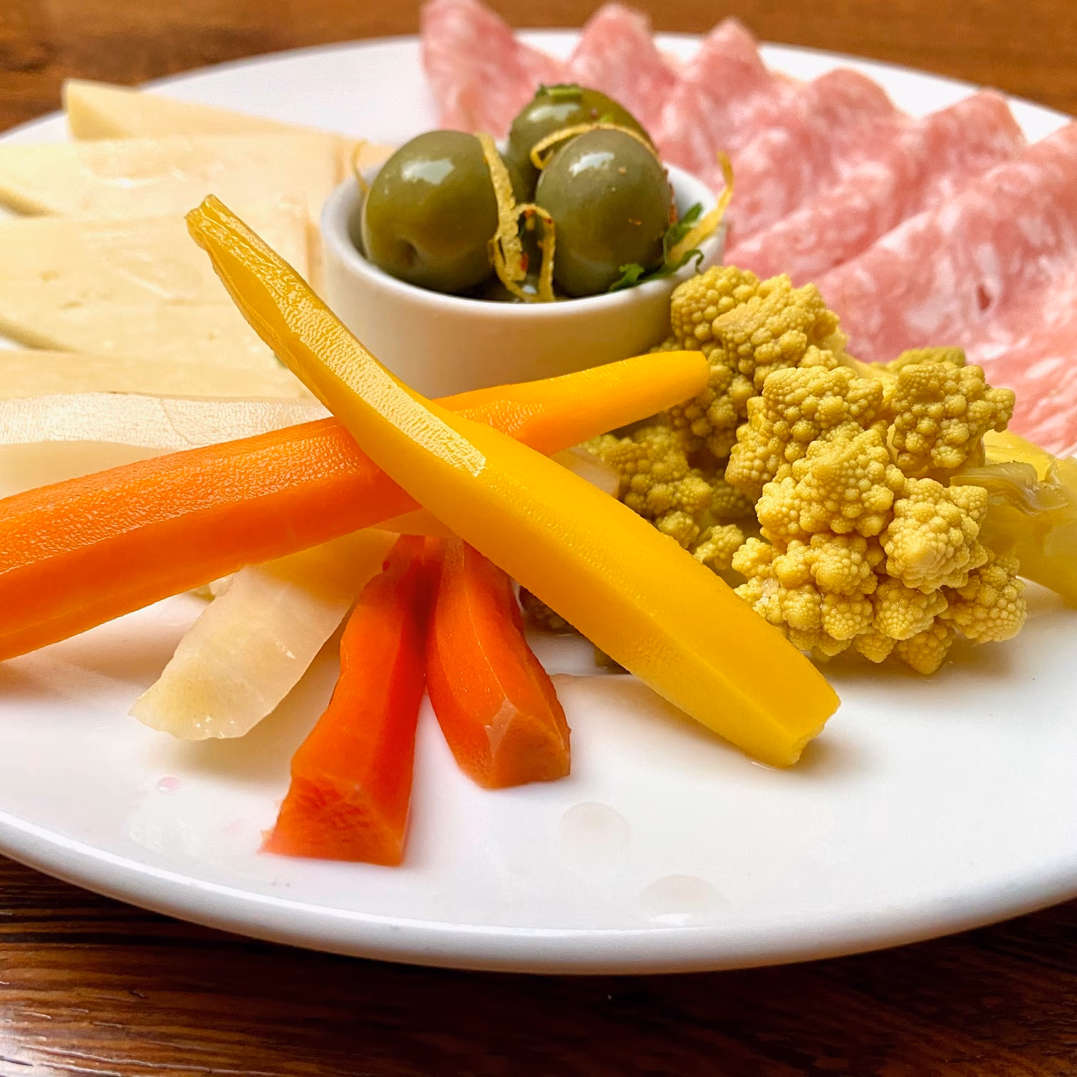 Antipasto plate with cheese, cured meats, olives, and pickled vegetables.