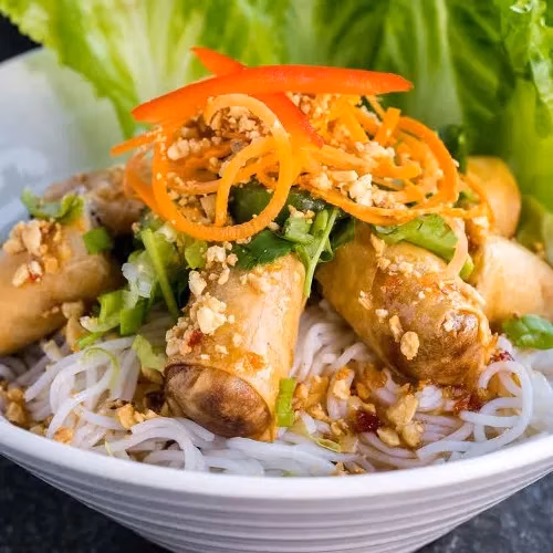 Fried spring rolls and rice vermicelli noodles with carrots, peanuts, lettuce.