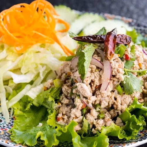 Minced meat salad with lettuce, carrots, cucumbers, and dried chilies.