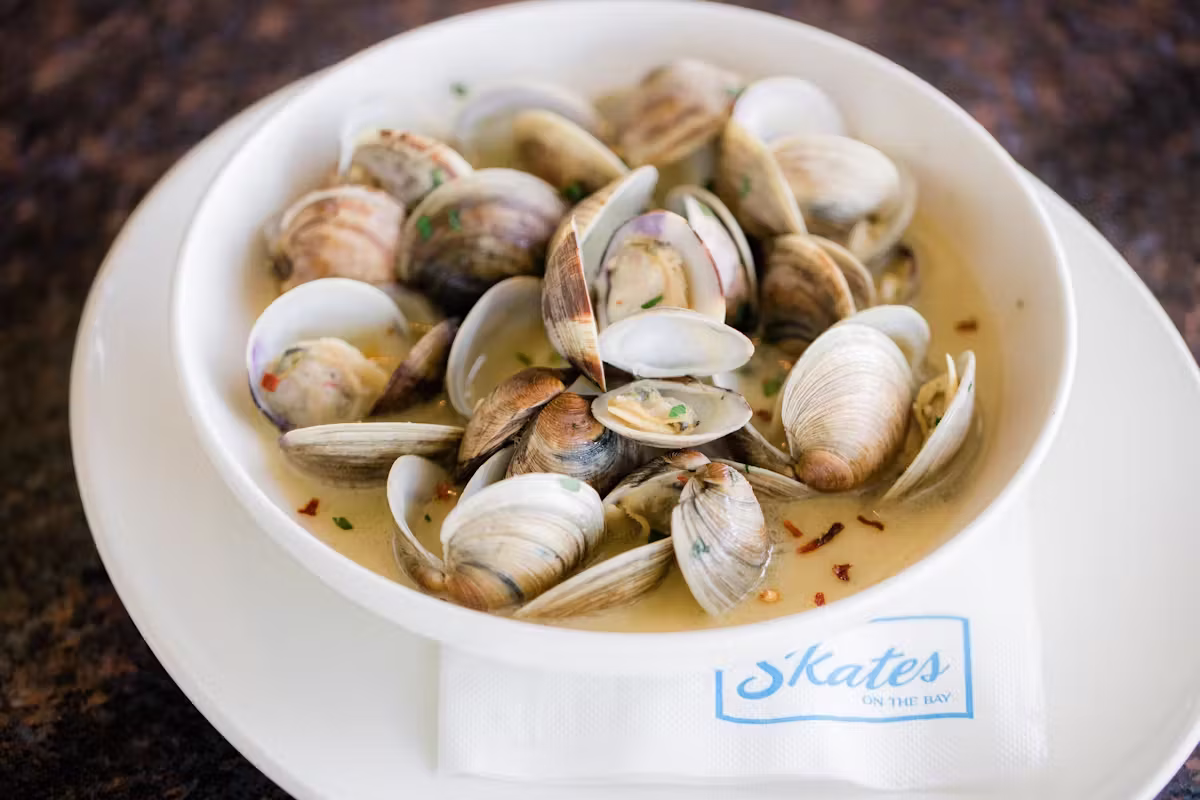 Steamed clams in a bowl, on a napkin with Skates ON THE BAY.