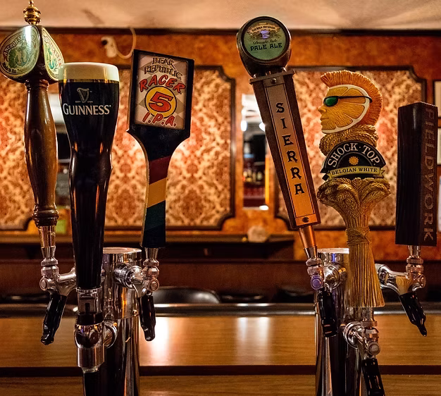 Beer taps from Guinness, Shock Top, and Sierra Nevada on a bar.