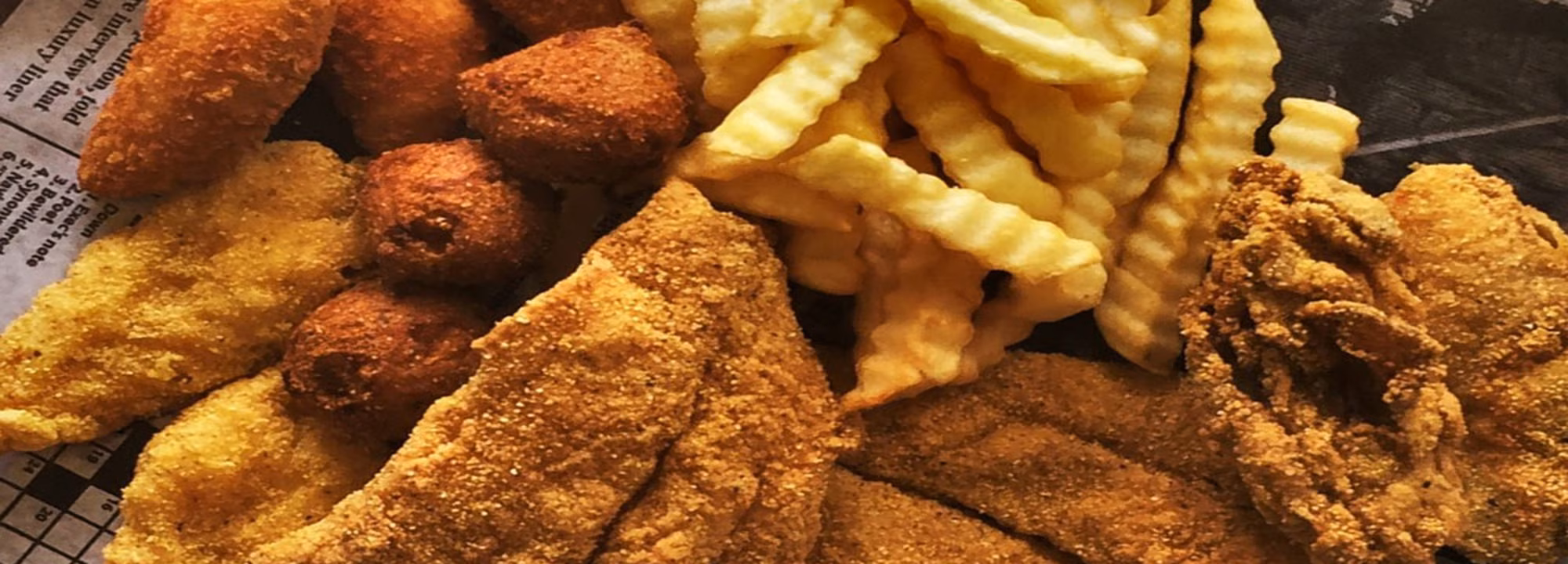 Fried fish fillets, hushpuppies, and crinkle-cut fries.