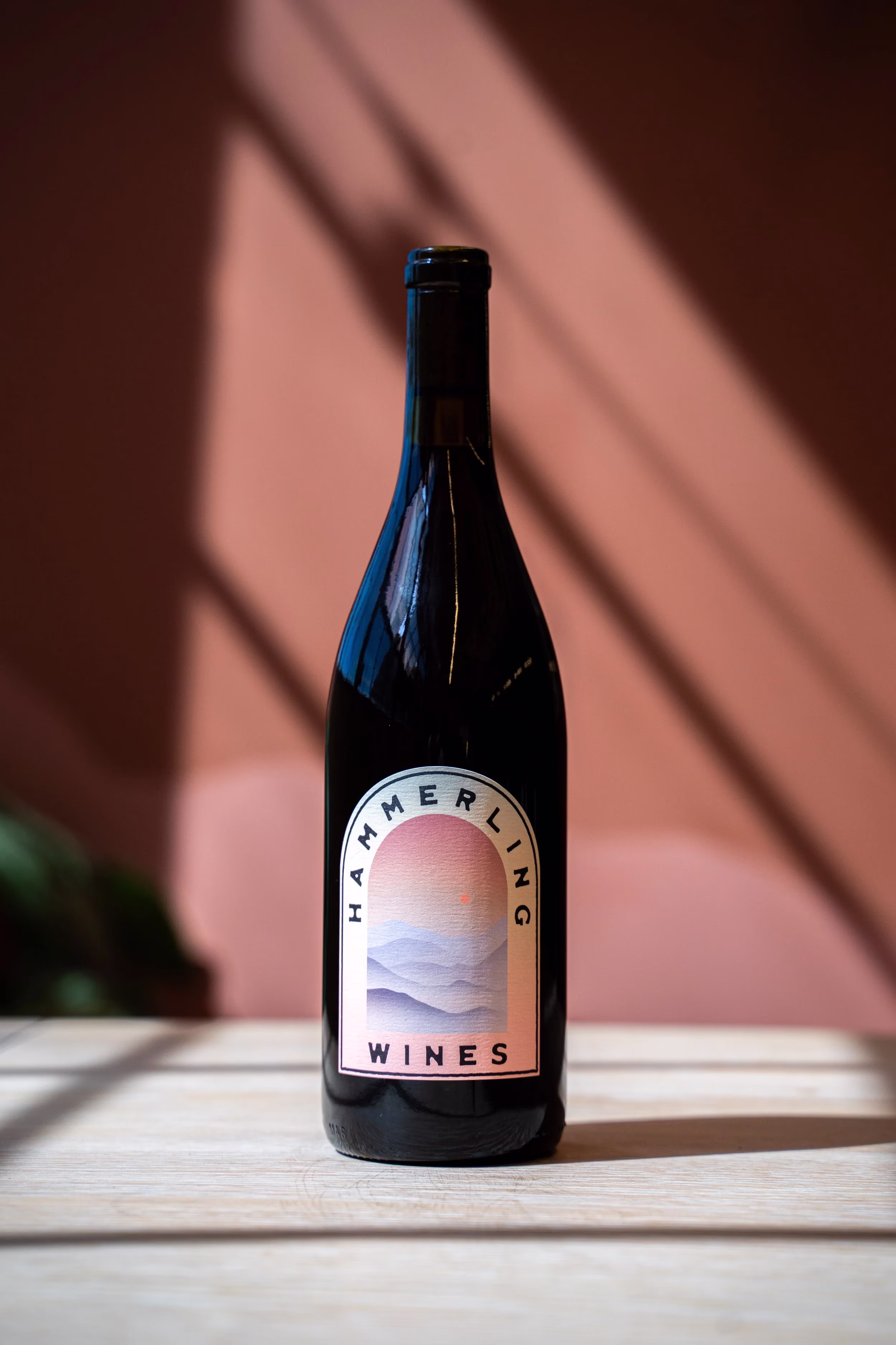 Dark Hammerling Wines bottle with landscape label, pink background.