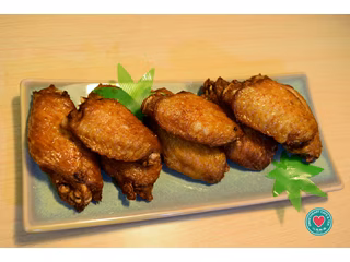 Seven golden-brown fried chicken wings arranged on a rectangular plate.