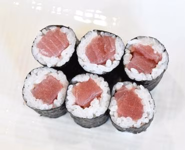 Six maki sushi rolls with pink filling.