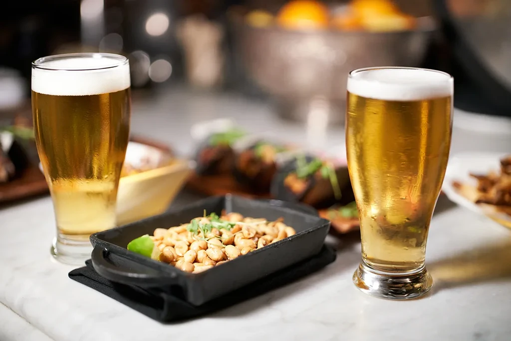 Two cold beers and roasted peanuts with herbs and lime.