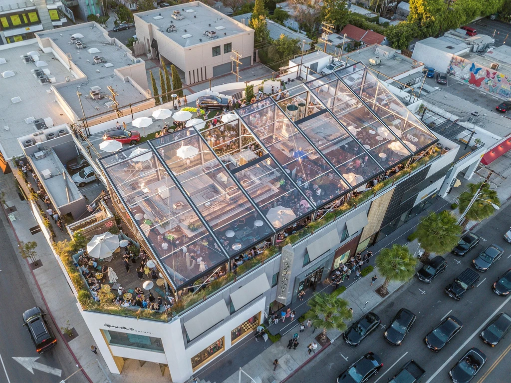High-angle view of a bustling rooftop restaurant under a clear tent.