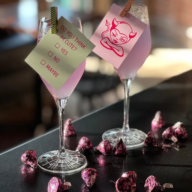 Pink cocktails with playful tags and foil-wrapped magenta chocolates.
