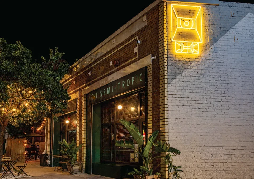 The Semi-Tropic restaurant exterior at night with neon sign and string lights.