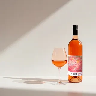 Still life with rosé wine bottle, glass, and prominent diagonal shadow.