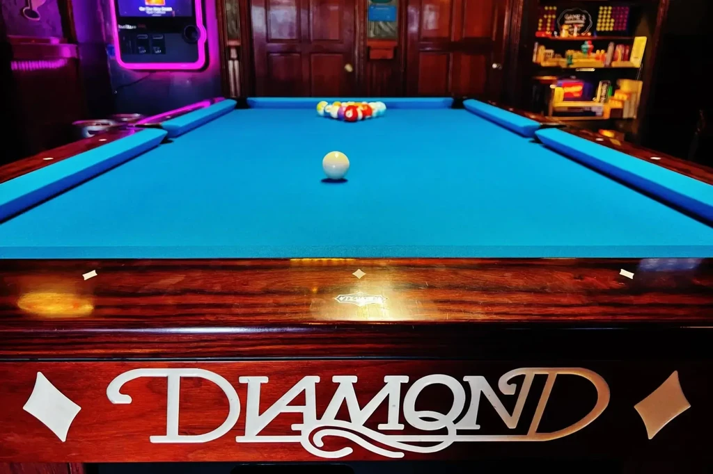 DIAMOND blue felt pool table with cue ball and racked balls.