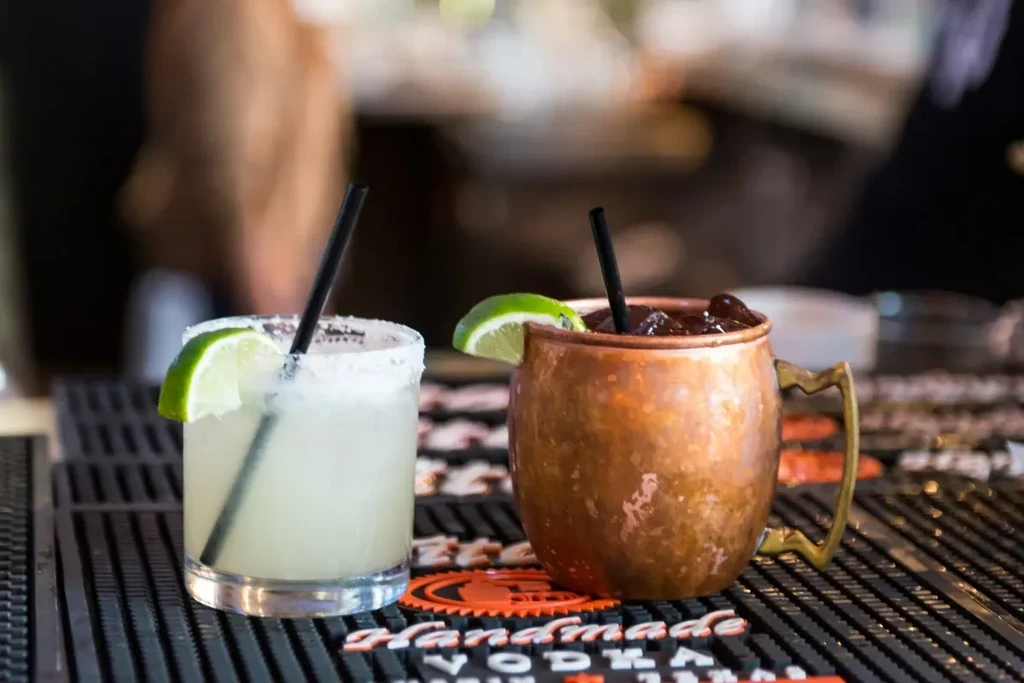 Margarita and Moscow mule on bar mat with 'HANDMADE VODKA' text.