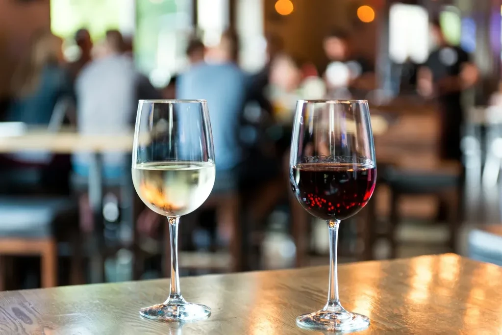 White and red wine in glasses on a restaurant table.