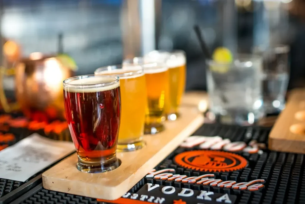 Four colorful beers on a flight paddle at a bar.