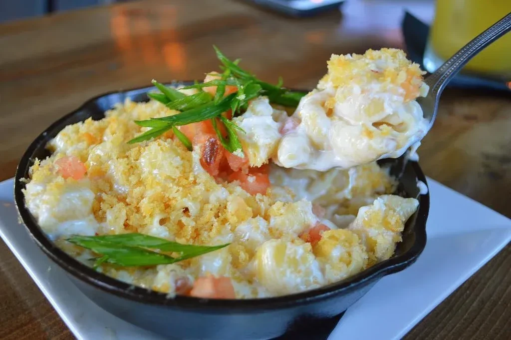 Mac and cheese with tomatoes, scallions, breadcrumbs lifted from skillet.
