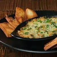 Baked creamy dip with golden breadcrumbs and dipping chips.