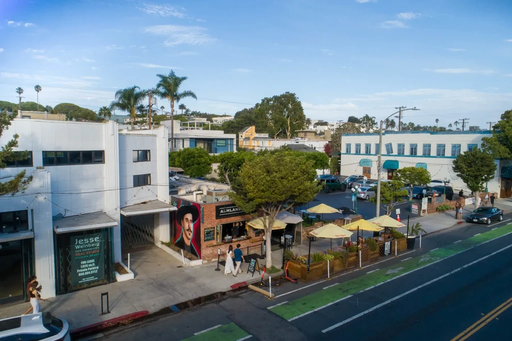 Bustling street from above: real estate, Ashland restaurant, outdoor dining, bike lane.