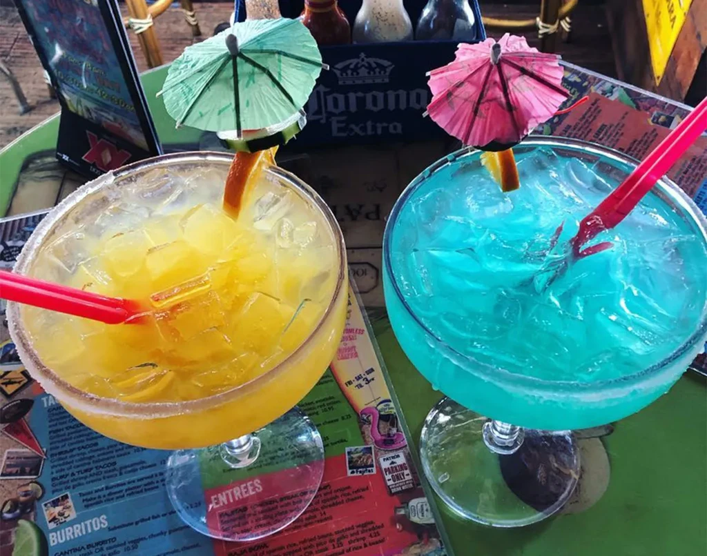 Yellow and blue cocktails with umbrellas and salted rims.